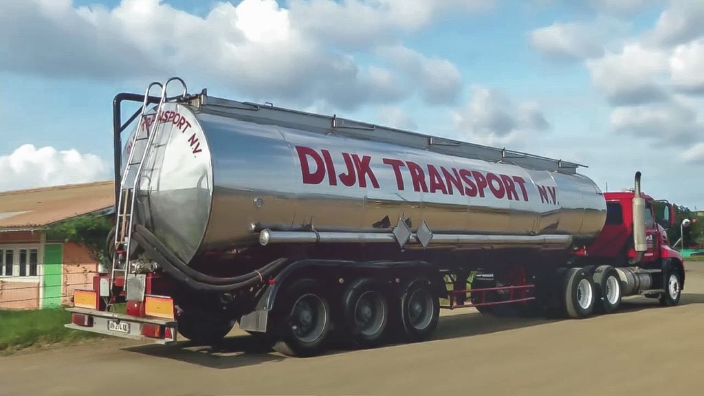 Red truck from Dijk Transport Curacao driving on the road.