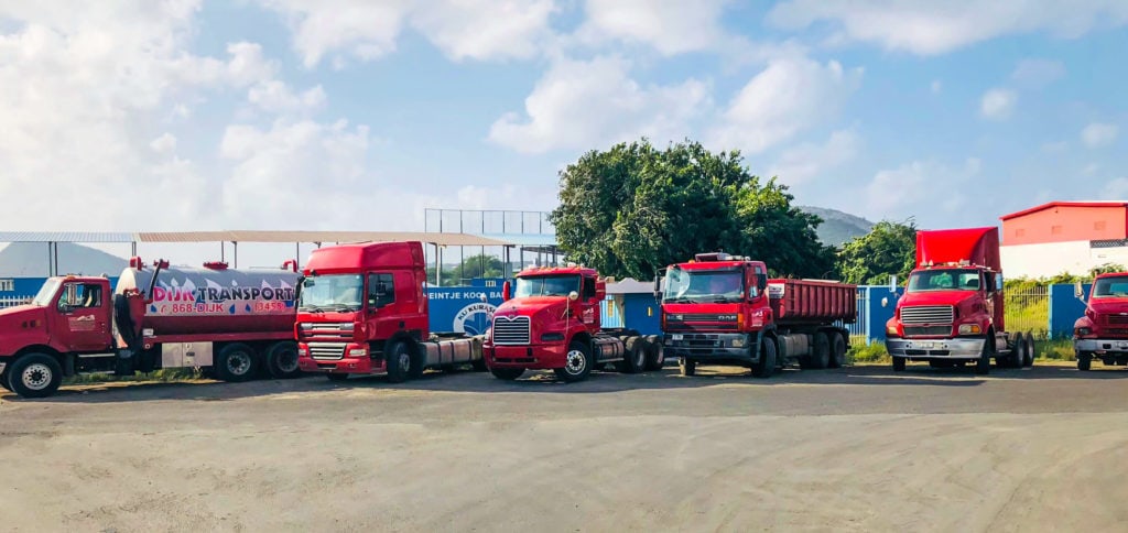 Line of red trucks from Dijk Transport in front of Heintje Kool Ballpark Curacao