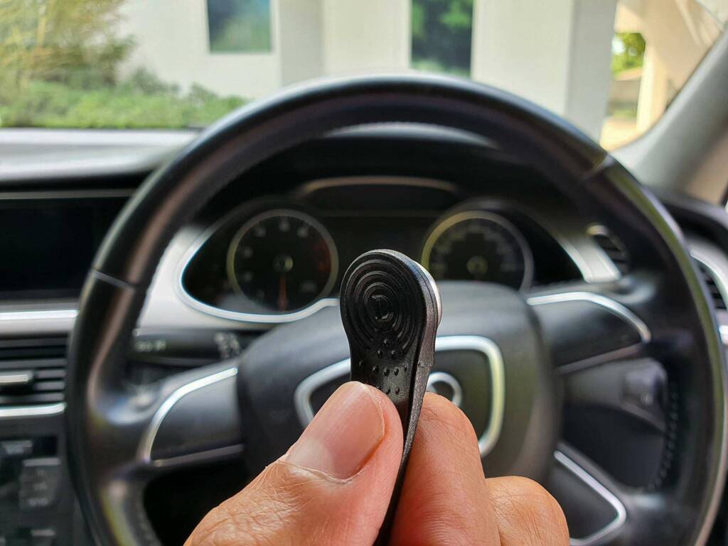 Axxon Drivertag or iButton in front of a vehicle dashboard to unlock the immobilizer